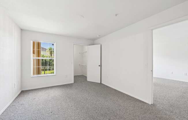 the living room of an apartment with white walls and carpet