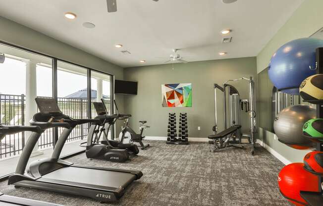 a gym with exercise equipment and a large window  at Aventura at Hawk Ridge, Missouri