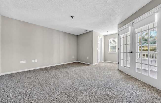 the living room and entryway of a house with white doors