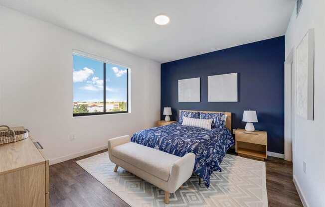 A bedroom with a bed and a blue wall and a window