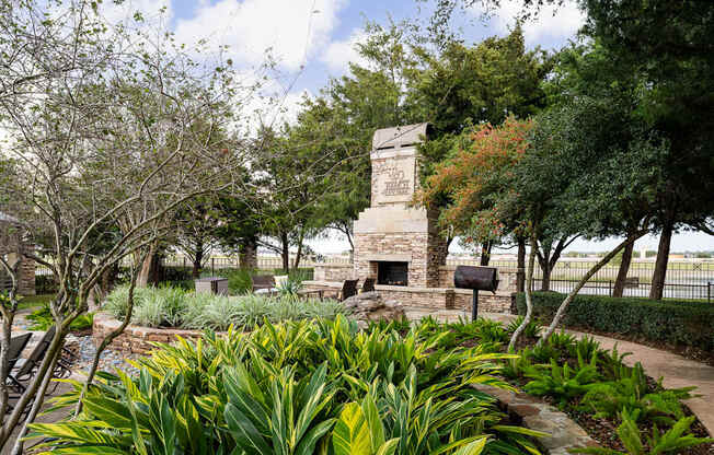 A stone monument is surrounded by green plants.