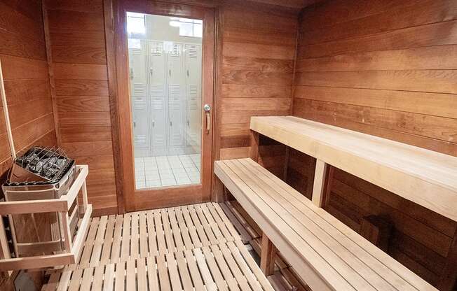 A wooden sauna with benches and a door.