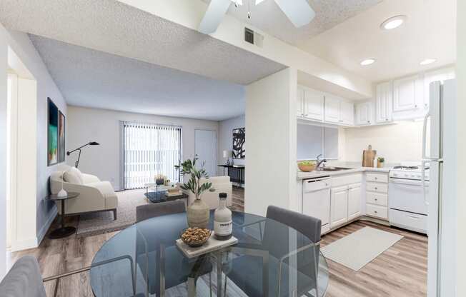 a living room with a glass table and a kitchen in the background at Redlands Park Apts, Redlands, CA
