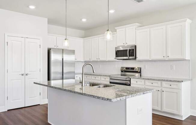 A kitchen with white cabinets and a granite countertop.