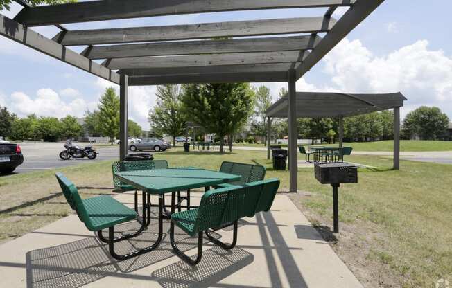 a picnic shelter with benches and tables at a park