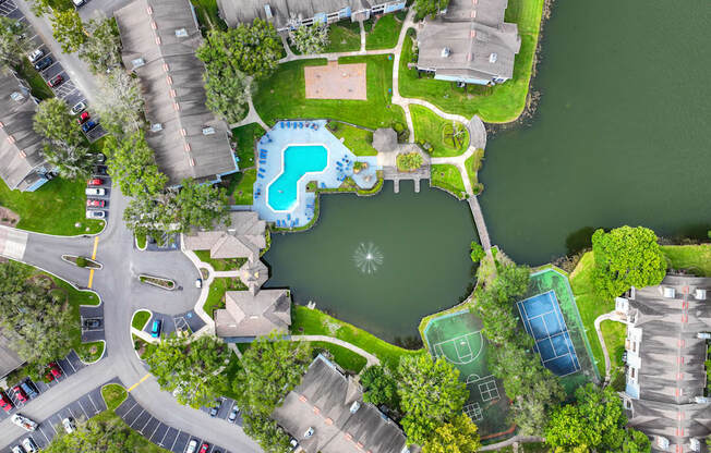 a birdseye view of a yard with a pool and a tennis court