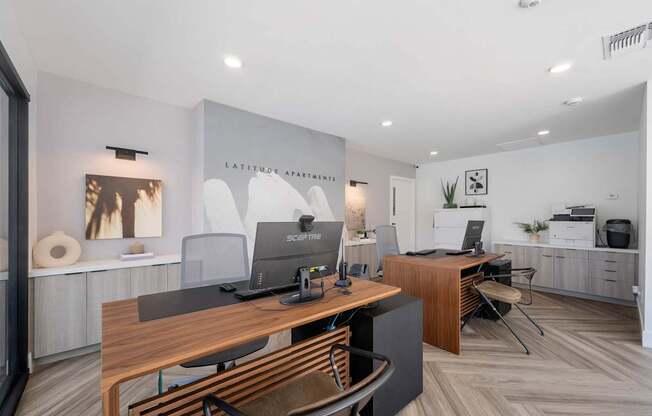 A modern office space with a wooden desk and chairs.