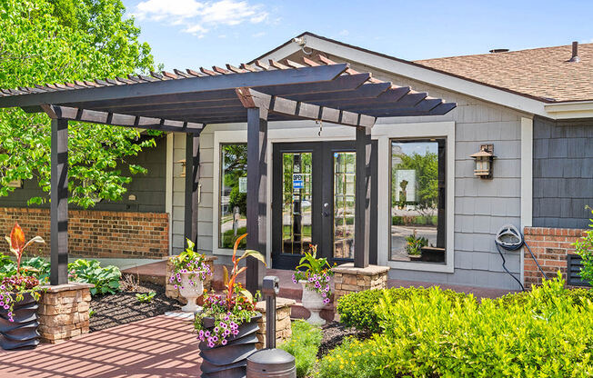 a patio with a pergola in front of a house