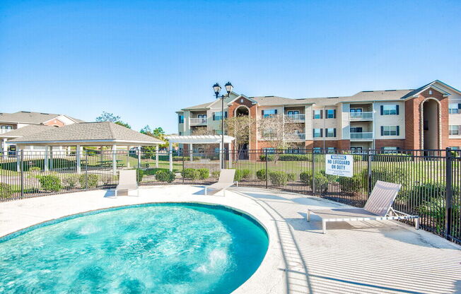 A pool in front of a building with a sign that says "Reserve Now".