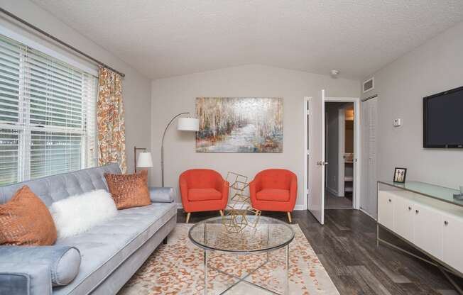 a living room with a couch and two chairs and a table