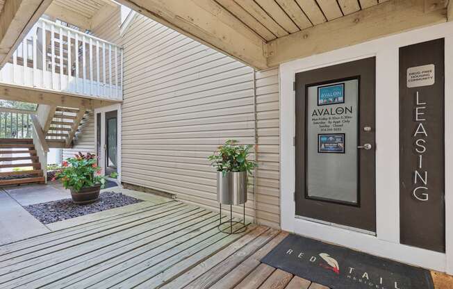 a front porch with a welcome rug in front of a door