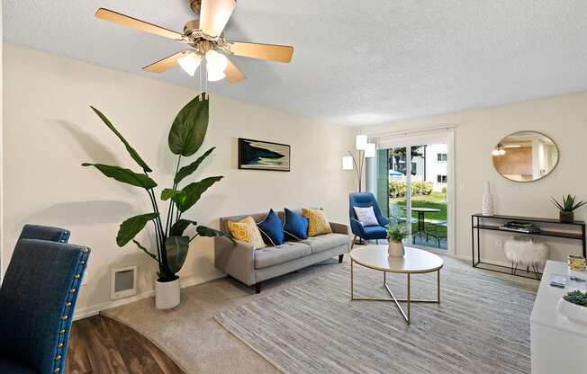 a living room with a couch coffee table and a ceiling fan at Pacific Park Apartment Homes, Edmonds, Washington 98026