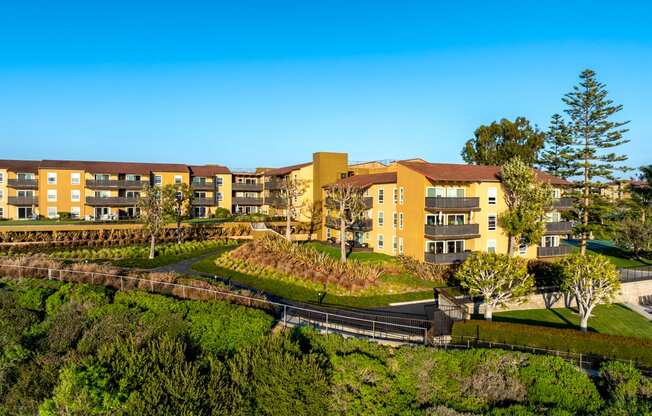 an aerial view of an apartment building on a hill with trees