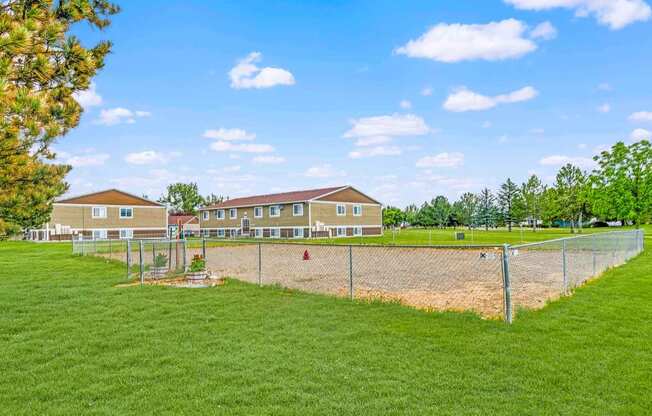 a fenced in area with houses in the background