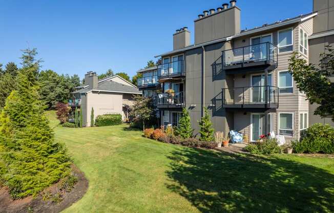 the view of an apartment building with a green lawn and trees