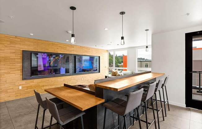 A modern dining room with a long wooden table and chairs.