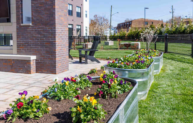 A garden with a brick pillar and a bench.