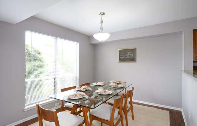 A dining room with a glass table and chairs.