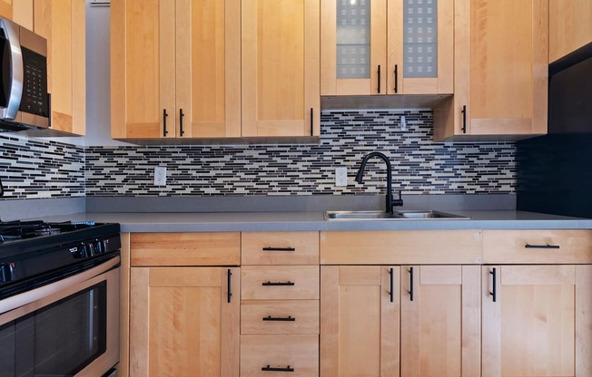 A kitchen with wooden cabinets and a black stove top oven.