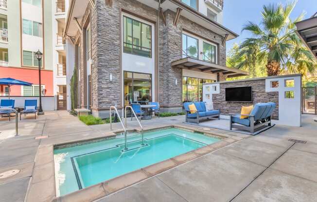 a swimming pool with chairs and a building with a fireplace at Metro Gateway, Riverside, CA, 92503