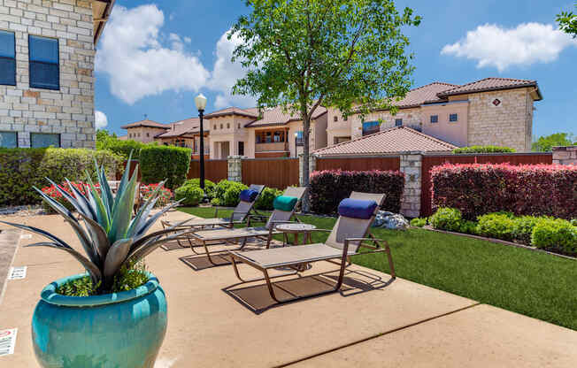 a patio with chairs and a potted plant