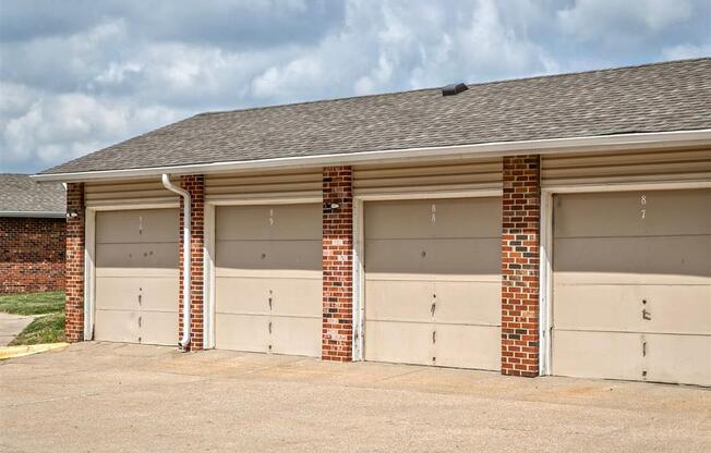 three garage doors on the side of a brick building