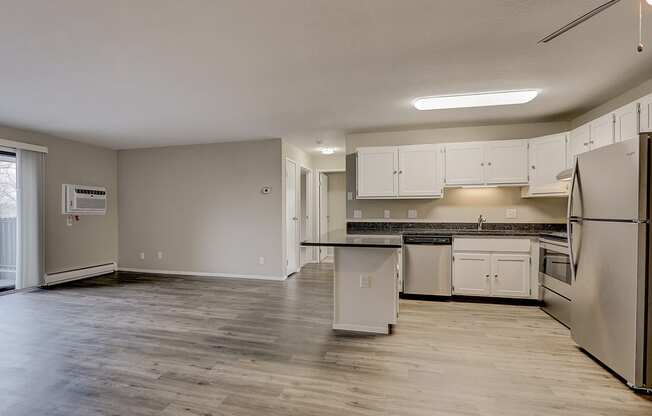 an empty kitchen with white cabinets and stainless steel appliances