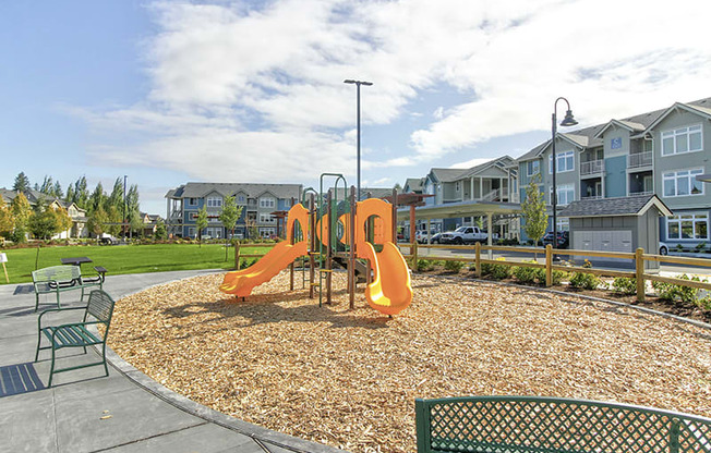 Olympia WA Apartments for Rent - Briggs Village - Playground Area with Yellow Slides, Tables, and Chairs