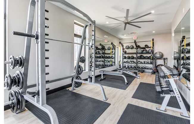 A gym with a variety of equipment including weights and benches.
