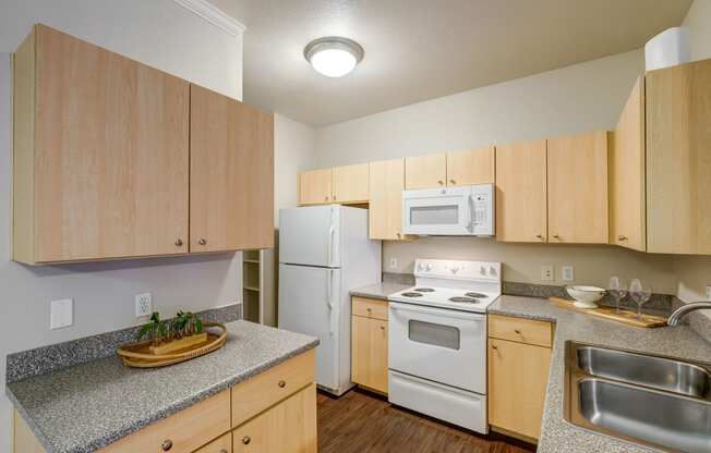 a kitchen with white appliances and granite counter tops