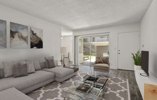 a living room with a couch and a glass coffee table at Pacific Rose, Los Angeles