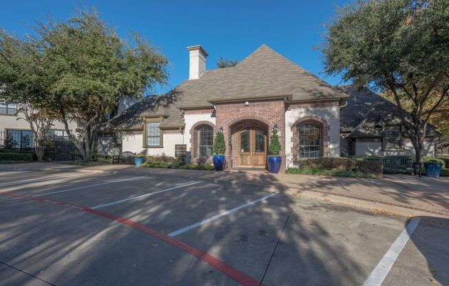 a house with a driveway and trees in front of it