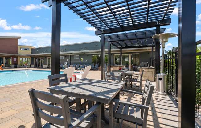 a patio with tables, chairs and a pool at TRIO @ Southbridge apartments