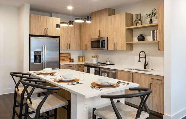 a kitchen with a large island with chairs and a table