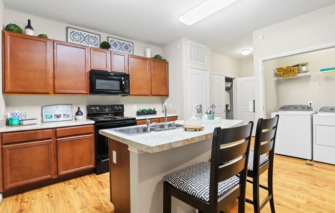 a kitchen with wooden cabinets and a white counter top with three black chairs