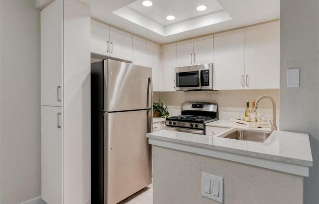 a kitchen with a refrigerator freezer next to a stove top oven  at Laguna Gardens Apts., California