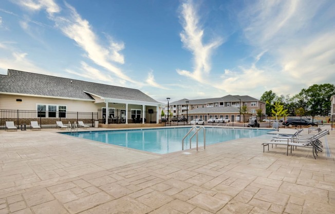 Swimming pool with chaise lounge chairs and Aurora's clubhouse in the background