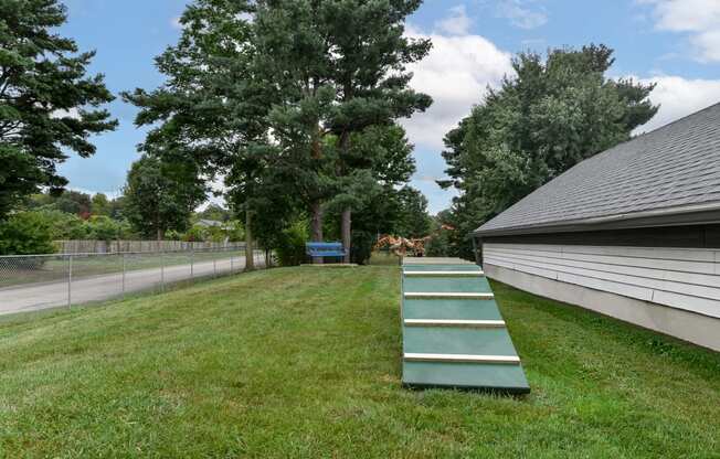 a green ramp in the grass next to a house