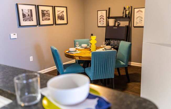 A dining table with four chairs and a bowl on the table.