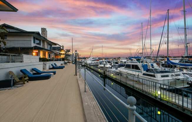 a marina at sunset with boats in the water and a house on the side of the
