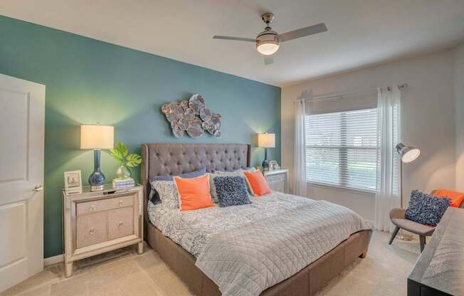 A bedroom with a bed, nightstand, and a ceiling fan.