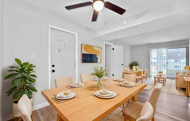 A dining room with a wooden table set for a meal.