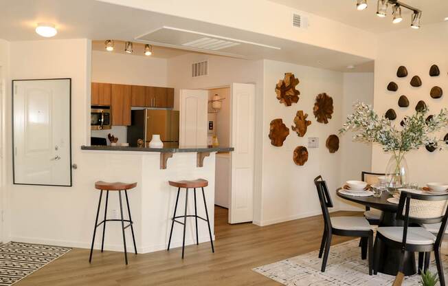 A modern kitchen with a dining table set for two.