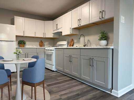 A kitchen with a table and chairs.
