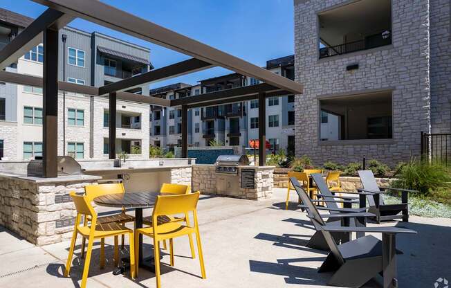 a patio with tables and chairs and a grill at the axis at princeton yards