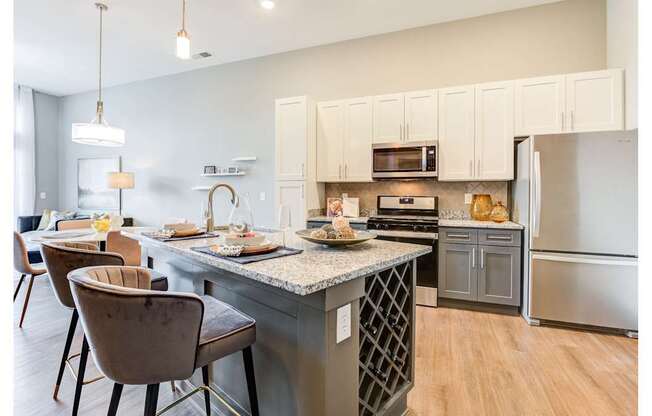 A kitchen with a table and chairs in front of it.