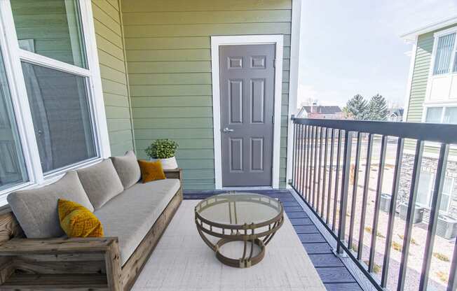 a patio with a couch and a table in front of a door