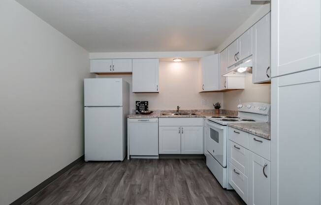 a kitchen with white cabinets and a white refrigerator