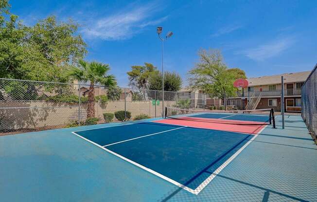 A tennis court with a red and white line in the middle.