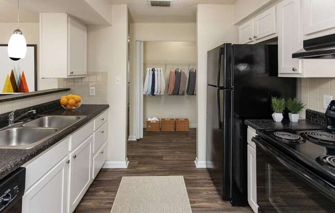 A kitchen with black appliances and white cabinets.
